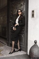 a lady in a white shirt, a black blazer and a black slit skirt